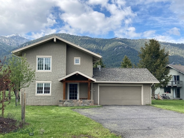 view of front of house with a mountain view, a garage, and a front yard