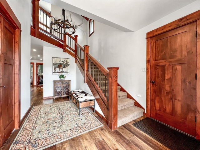 entrance foyer featuring a high ceiling, hardwood / wood-style flooring, and a notable chandelier