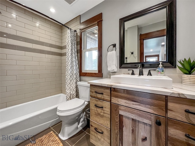 full bathroom featuring shower / tub combo with curtain, vanity, tile patterned flooring, and toilet