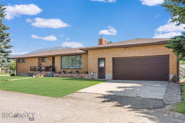 ranch-style home with a garage, brick siding, a chimney, and a front yard