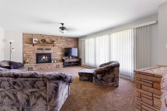 living room with ceiling fan, carpet floors, a stone fireplace, and a baseboard radiator