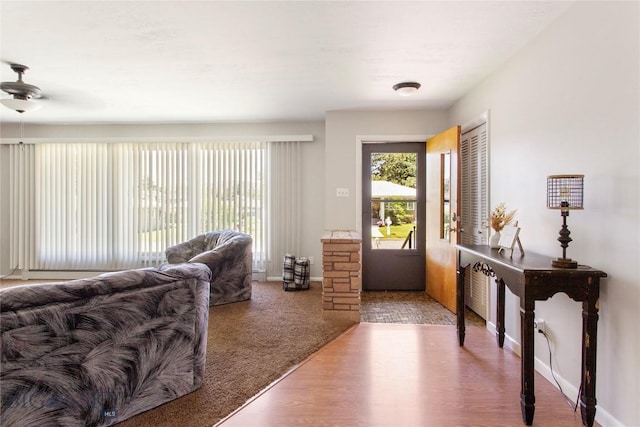 interior space featuring wood finished floors, a ceiling fan, and baseboards