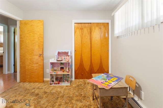 game room featuring a baseboard heating unit and carpet