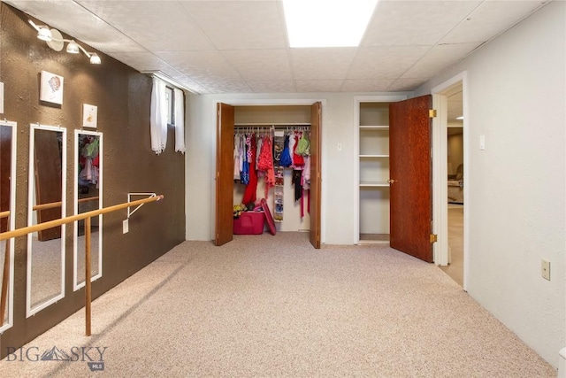 interior space with carpet flooring and a paneled ceiling