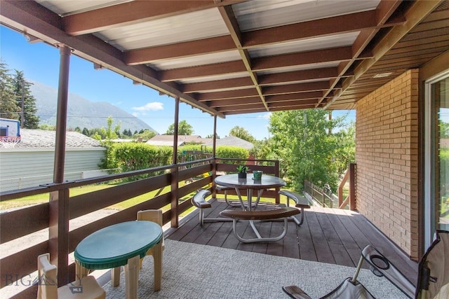 wooden deck featuring a mountain view and outdoor dining area