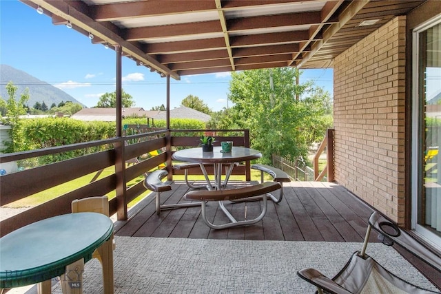 wooden terrace featuring outdoor dining area and a mountain view