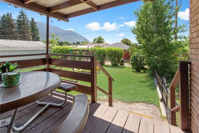 wooden terrace with a lawn and a mountain view