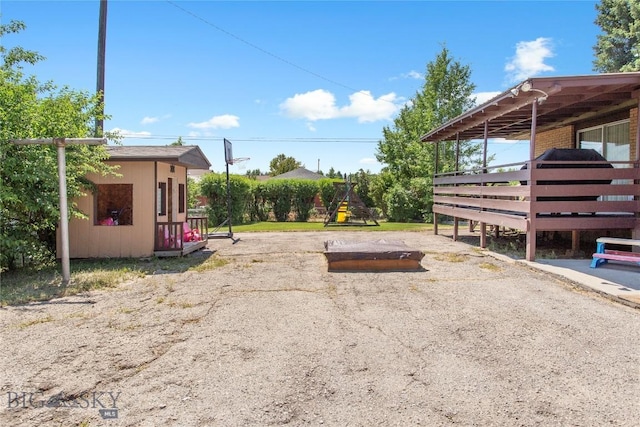 view of yard featuring a playground and an outbuilding