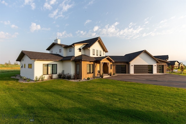 modern farmhouse style home featuring a garage and a lawn