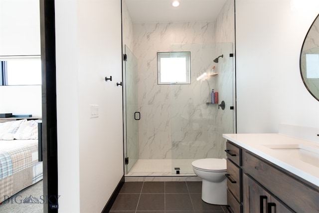 bathroom featuring tile patterned flooring, a shower with door, toilet, and vanity