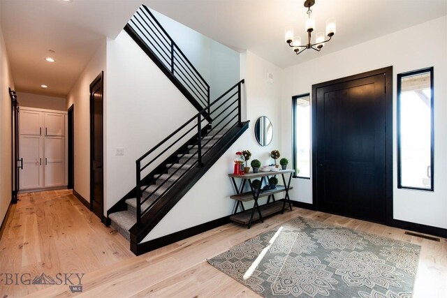 entryway featuring light hardwood / wood-style flooring, a wealth of natural light, and an inviting chandelier