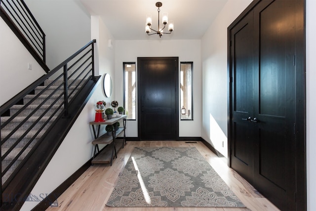 entryway with light hardwood / wood-style flooring and a chandelier