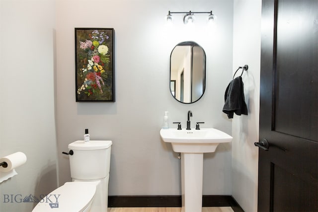 bathroom featuring hardwood / wood-style flooring and toilet