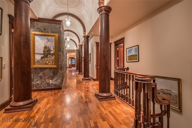 hallway featuring hardwood / wood-style floors and ornate columns