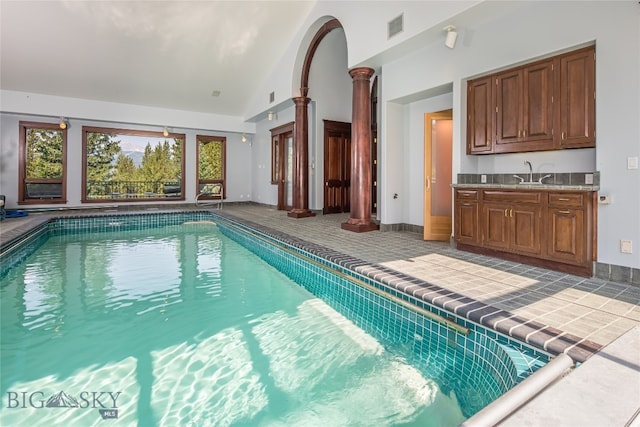 view of swimming pool with sink and ornate columns