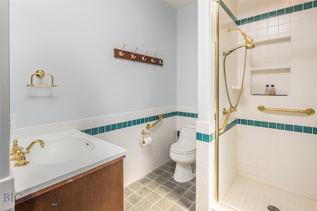 bathroom with vanity, an enclosed shower, tile patterned floors, toilet, and tile walls