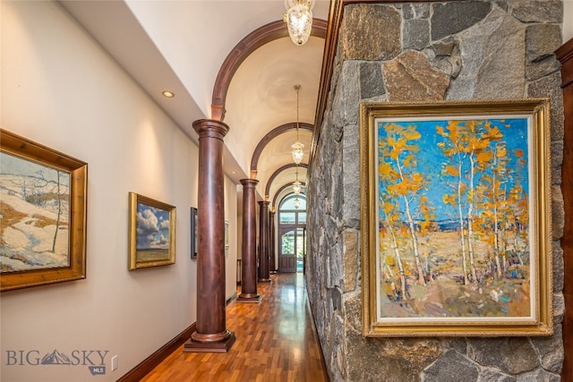 hallway with decorative columns, hardwood / wood-style flooring, and ornamental molding