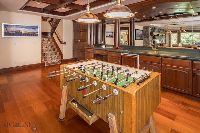 playroom with indoor wet bar, wood-type flooring, beamed ceiling, and coffered ceiling