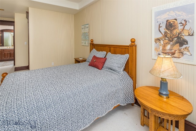 bedroom featuring ensuite bath and carpet floors