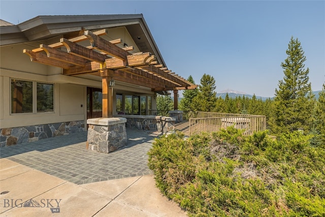 view of patio featuring an outdoor bar, a mountain view, and a pergola