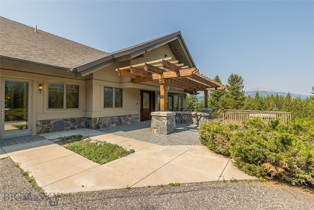 exterior space with a patio area, a pergola, and a mountain view