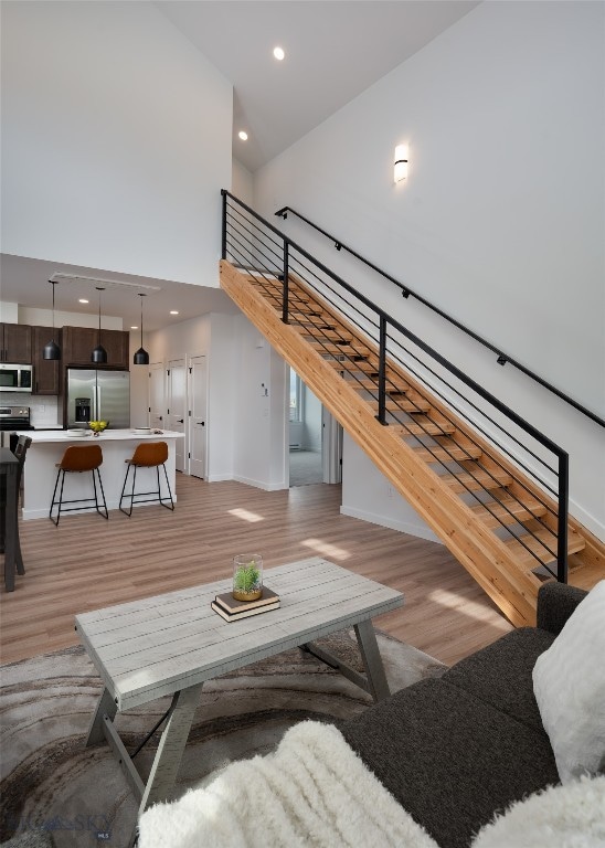 living room featuring light hardwood / wood-style floors and a towering ceiling