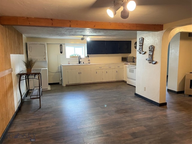 kitchen featuring beam ceiling, white range, white cabinets, dark hardwood / wood-style floors, and stacked washer and clothes dryer