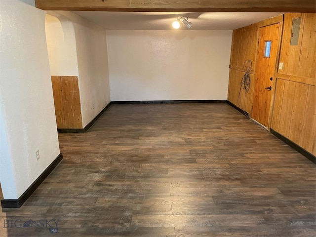 unfurnished room featuring beamed ceiling and dark hardwood / wood-style floors