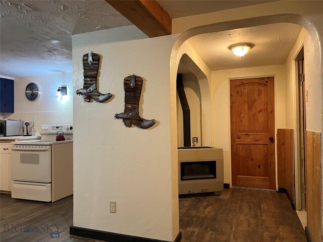 kitchen featuring beamed ceiling, electric stove, a textured ceiling, dark hardwood / wood-style floors, and white cabinetry