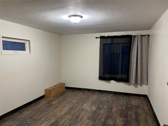 empty room featuring a textured ceiling and wood-type flooring