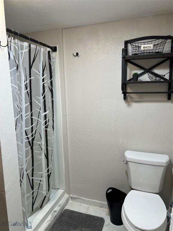 bathroom featuring tile patterned floors, walk in shower, and toilet