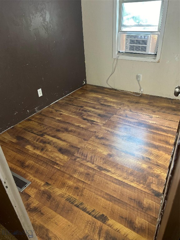 empty room featuring wood-type flooring and cooling unit