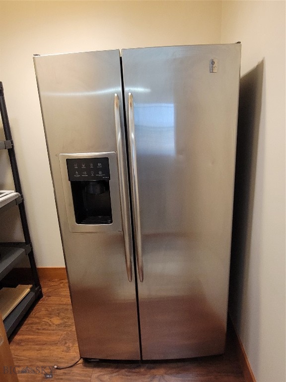 interior details with dark hardwood / wood-style flooring and stainless steel fridge with ice dispenser