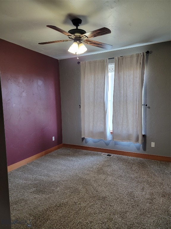 carpeted spare room featuring ceiling fan