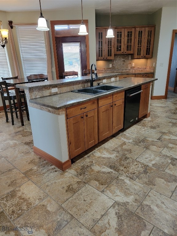 kitchen featuring dishwasher, a center island with sink, hanging light fixtures, and sink