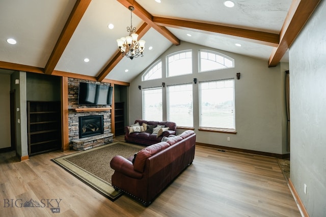 living room with a stone fireplace, a chandelier, light hardwood / wood-style floors, and lofted ceiling with beams