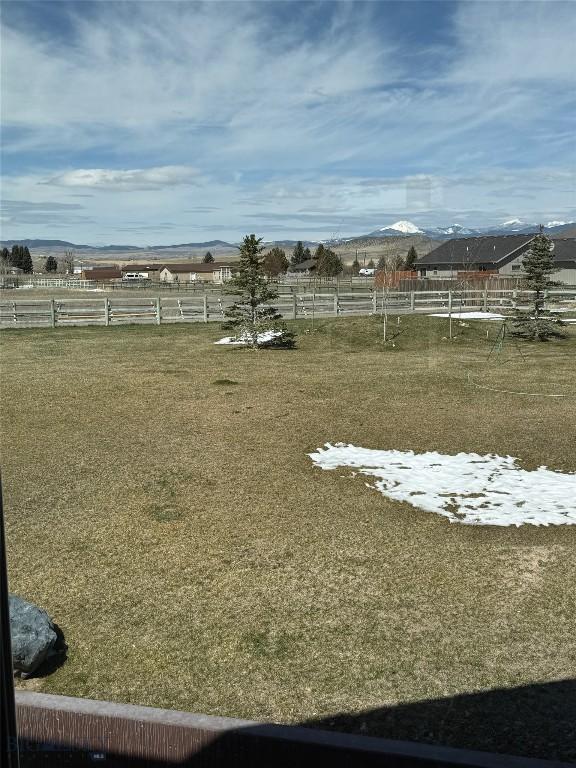 view of yard featuring fence and a rural view