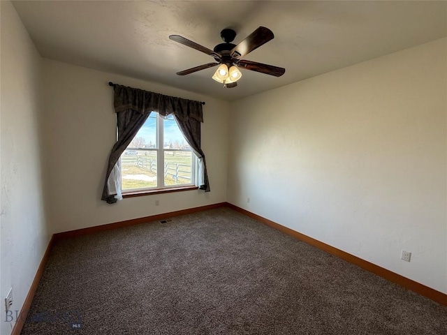 carpeted empty room featuring a ceiling fan and baseboards