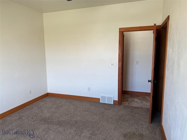 carpeted empty room featuring visible vents and baseboards