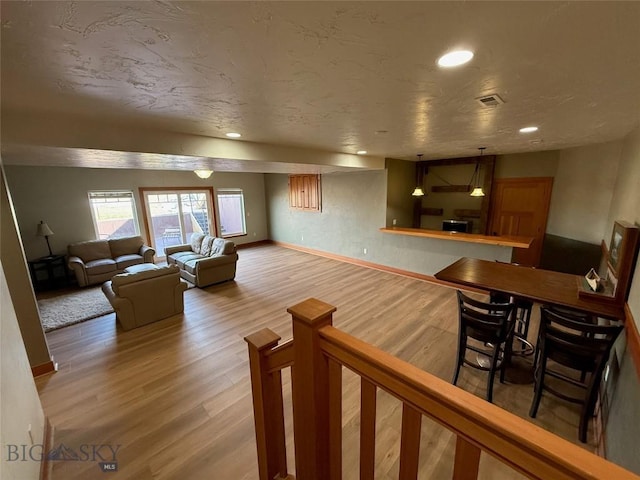 living room with recessed lighting, wood finished floors, visible vents, and baseboards