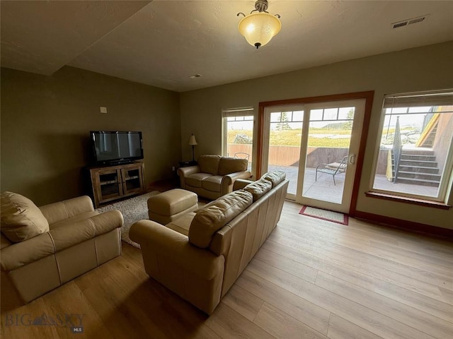 living room with light wood-type flooring and visible vents