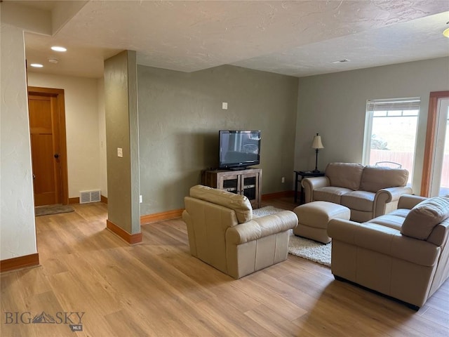 living area featuring recessed lighting, visible vents, light wood finished floors, and baseboards