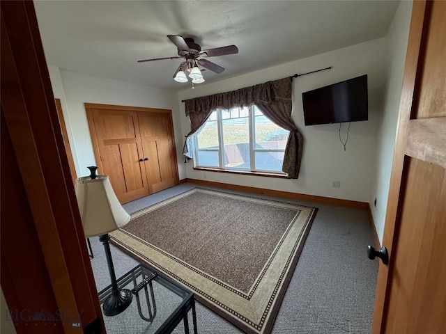 unfurnished office featuring carpet floors, baseboards, and ceiling fan