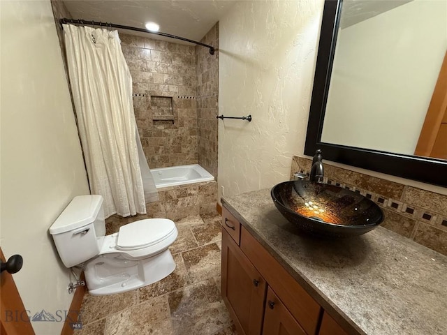 bathroom with vanity, tiled shower / bath, and toilet