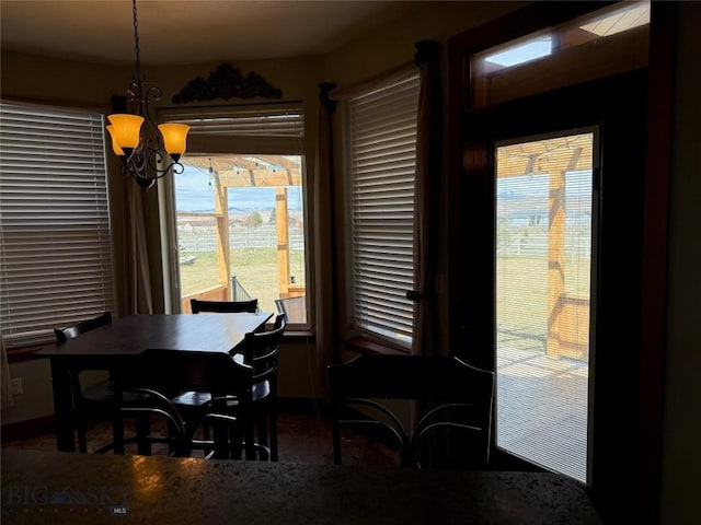 dining area with an inviting chandelier and baseboards