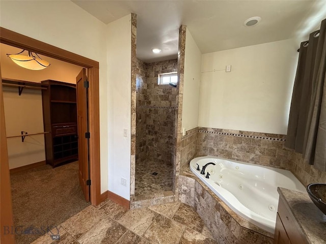full bath with a walk in closet, a whirlpool tub, baseboards, and a stall shower