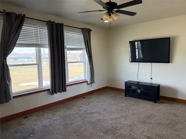 unfurnished living room with carpet, visible vents, baseboards, and ceiling fan