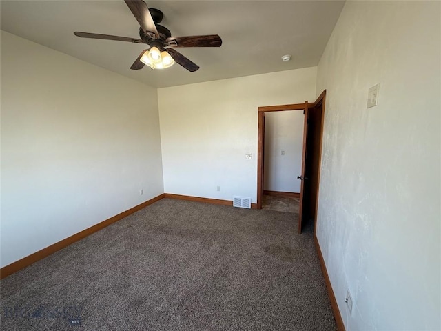 carpeted spare room featuring visible vents, baseboards, and ceiling fan