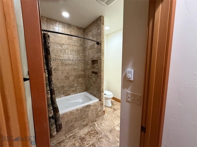 bathroom with tiled shower / bath, visible vents, and toilet