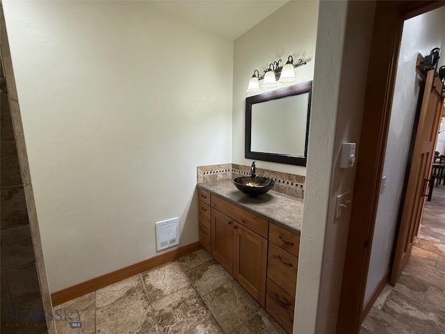 bathroom featuring baseboards, stone finish floor, vanity, and visible vents